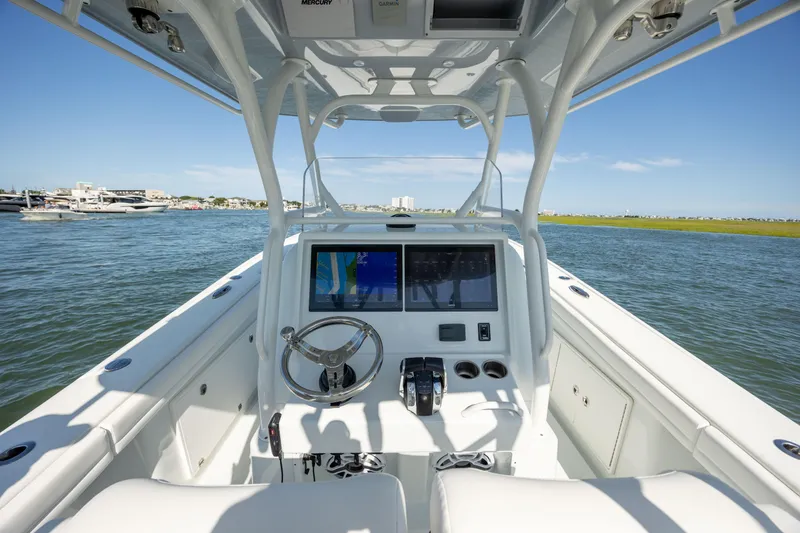 Slide: The Image of 2022 Yellowfin 34 boat cockpit with steering wheel and navigation screens on open water. - 10