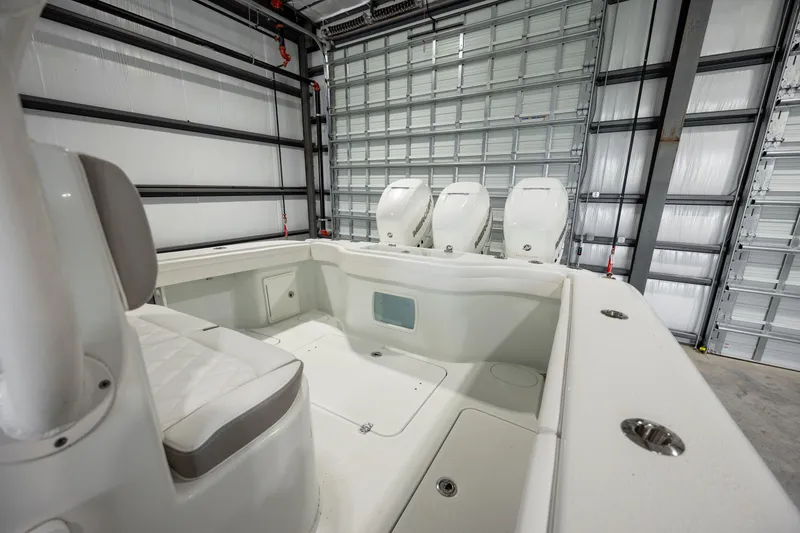Slide: The Image of 2022 Yellowfin 34 boat interior in a garage, showcasing seating and storage areas. - 12