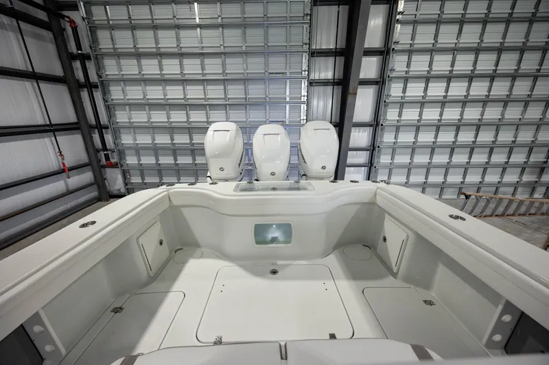 Slide: The Image of 2022 Yellowfin 34 boat interior with triple outboard engines in a storage facility. - 13