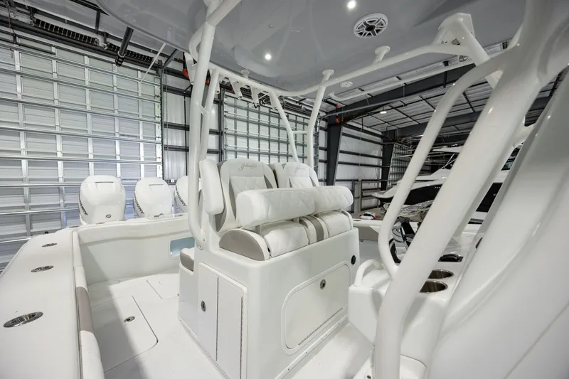 Slide: The Image of 2022 Yellowfin 34 boat interior with white seating and modern design in a garage. - 14