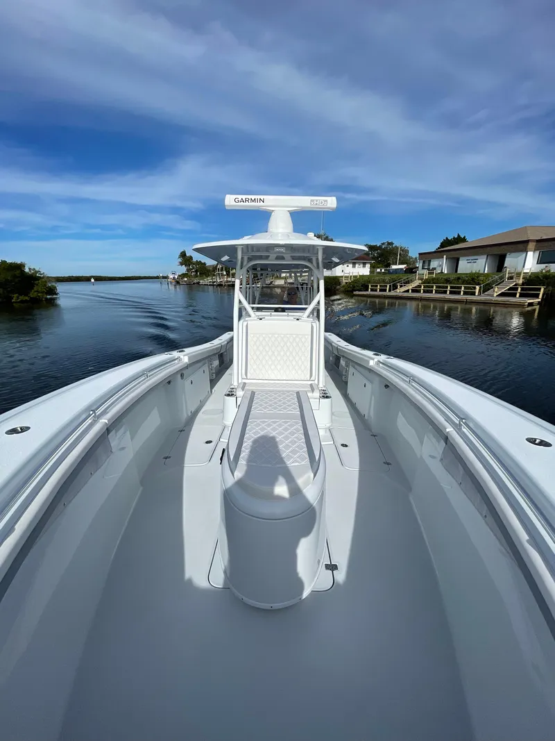 Slide: The Image of 2022 Yellowfin 34 boat on a calm waterway under a clear blue sky. - 15