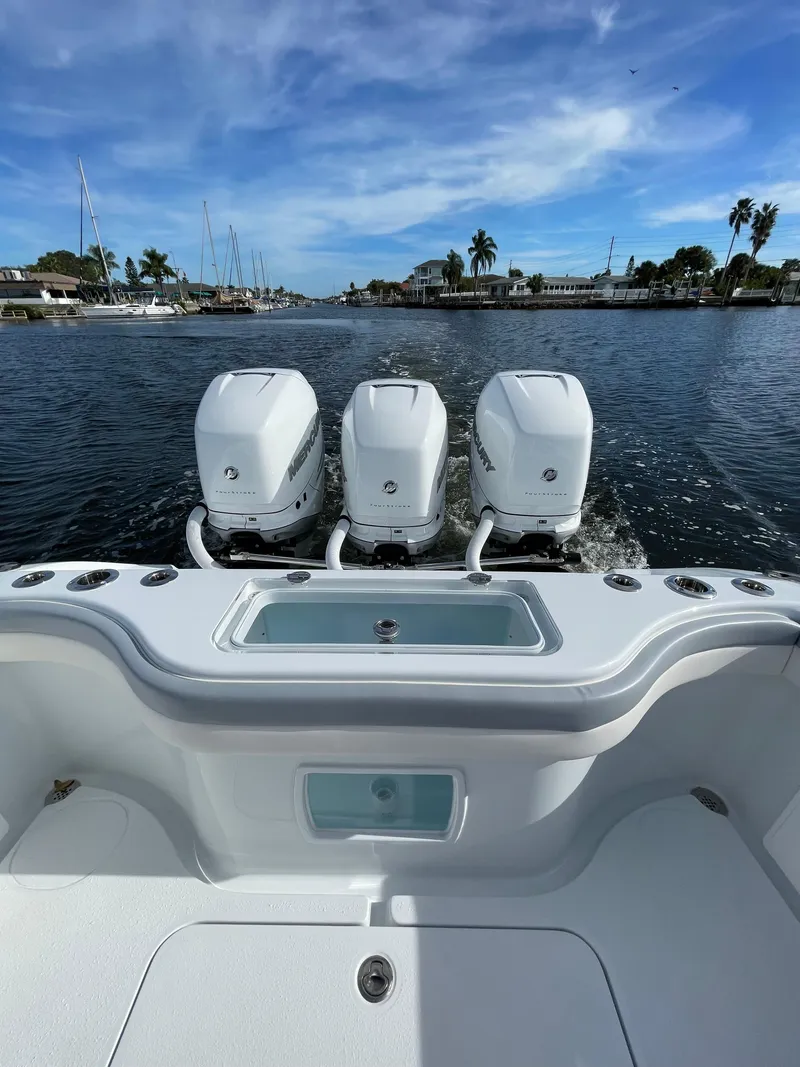 Slide: The Image of 2022 Yellowfin 34 boat with triple outboard engines on a scenic waterway. - 43