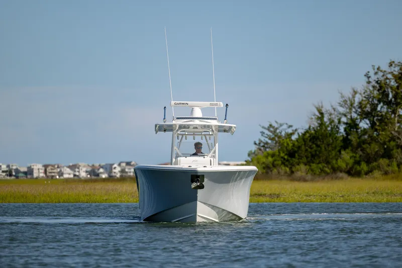 Slide: The Image of 2022 Yellowfin 34 boat cruising on calm water near shoreline. - 5