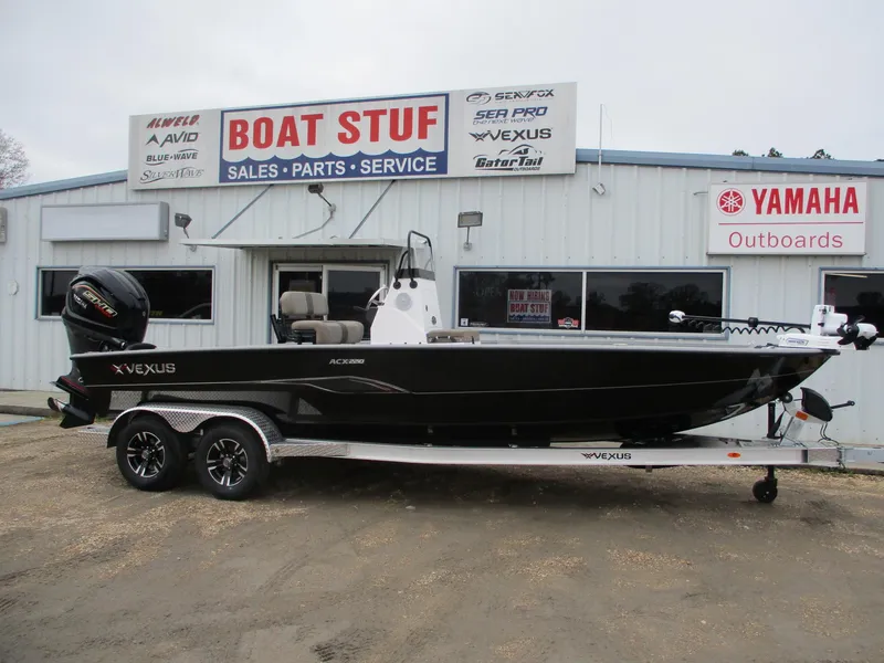 Slide: The Image of 2025 Vexus ACX 2210 boat on trailer outside dealership, featuring Yamaha outboard motor. - 0
