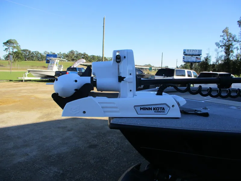 Slide: The Image of 2025 Vexus ACX 2210 boat with Minn Kota trolling motor in a parking lot. - 3