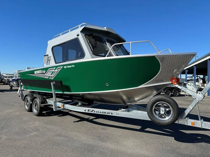 The Image of 2025 Hewescraft 220 Ocean Pro ET HT boat on trailer, green and white design. - 0