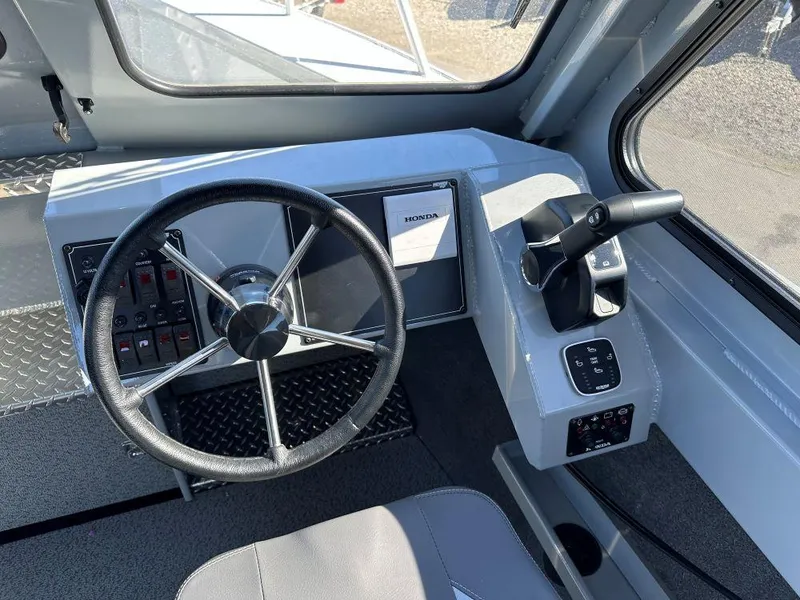Slide: The Image of 2025 Hewescraft 220 Ocean Pro ET HT boat helm with steering wheel and controls. - 6