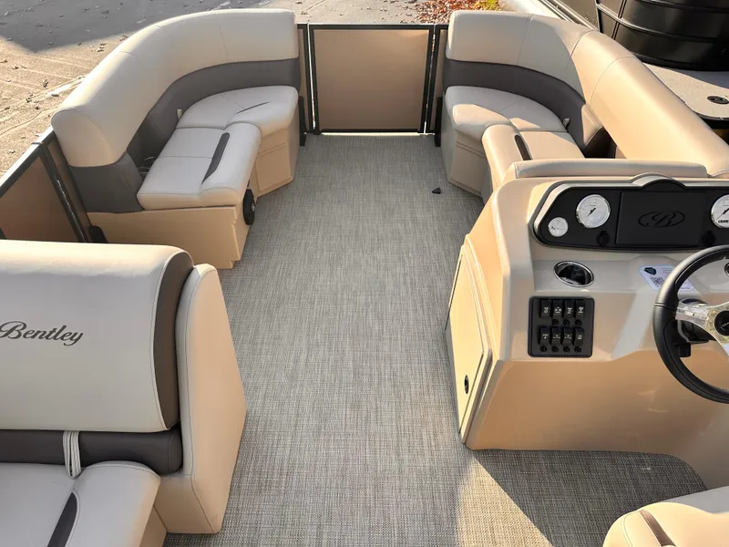 Slide: The Image of 2025 Bentley Pontoons LE 160CR interior with beige seating and modern dashboard. - 9