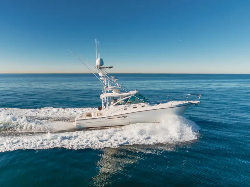 Slide: The Image of 2006 Rampage 38 Express yacht cruising on open sea under clear blue sky. - 14
