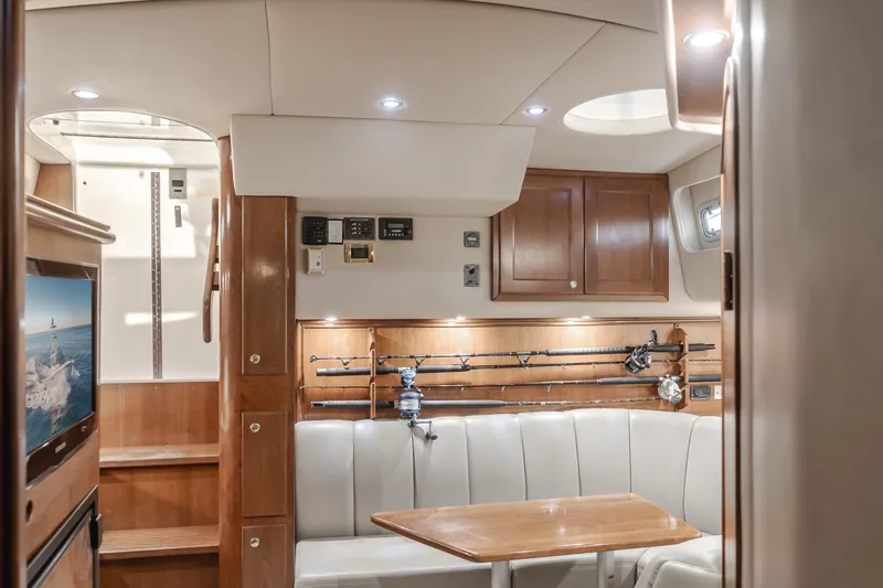 Slide: The Image of Luxurious 2006 Rampage 38 Express yacht interior with seating, fishing rods, and wooden cabinetry. - 29
