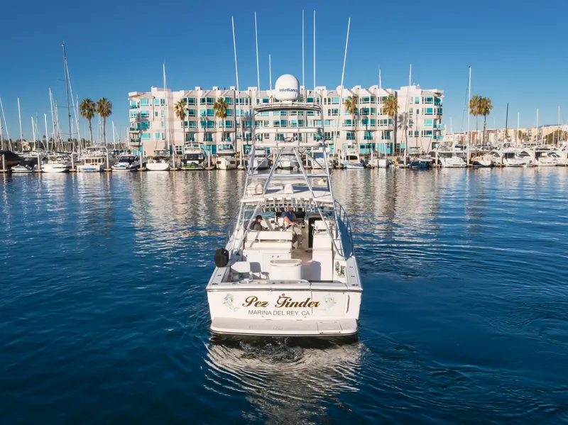 Slide: The Image of 2006 Rampage 38 Express boat in marina, with waterfront building and palm trees in background. - 3