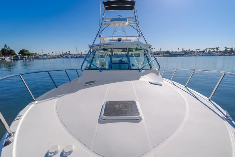 Slide: The Image of 2006 Rampage 38 Express boat on calm water, clear sky, marina in background. - 34