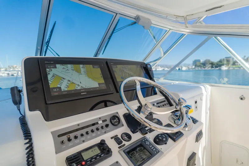 Slide: The Image of 2006 Rampage 38 Express boat helm with navigation screens and steering wheel. - 42
