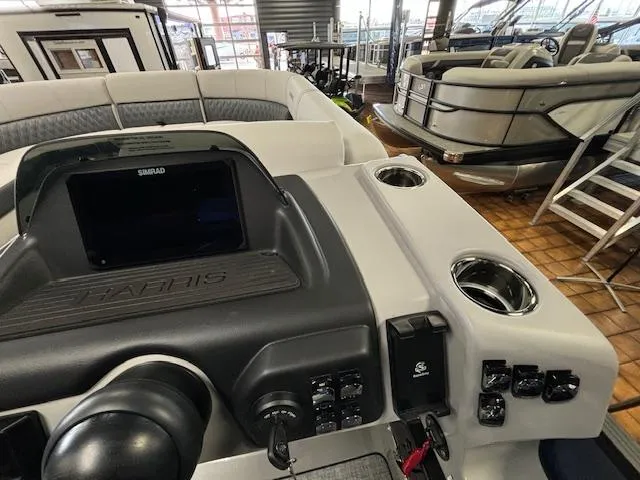 Slide: The Image of 2025 Harris SUNLINER 230 SLDH boat dashboard with controls and cup holders. - 31