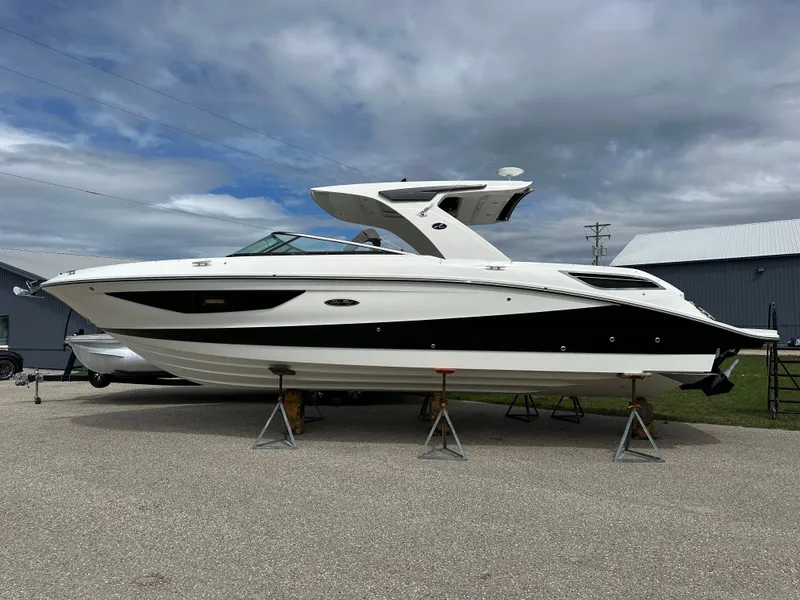 The Image of 2025 Sea Ray SLX 350 boat on stands, displayed outdoors under cloudy sky. - 0