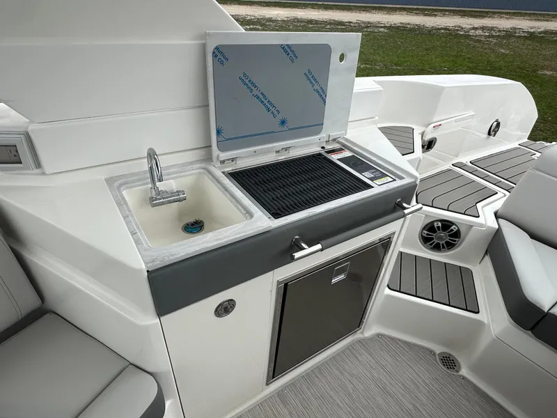 Slide: The Image of 2025 Sea Ray SLX 350 boat kitchenette with sink, grill, and storage. - 14