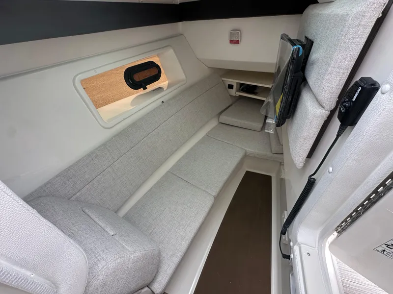 Slide: The Image of 2025 Sea Ray SLX 350 cabin interior with modern seating and window view. - 15