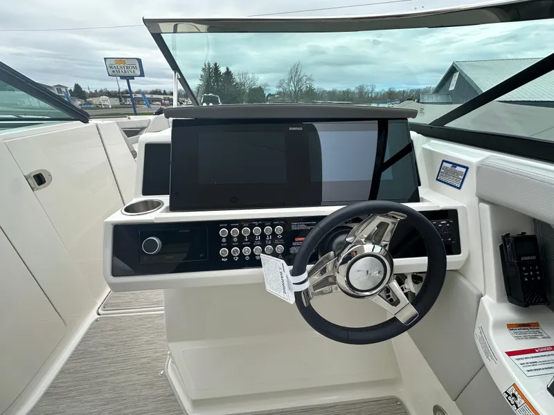 Slide: The Image of 2025 Sea Ray SLX 350 helm with modern controls and sleek steering wheel. - 9