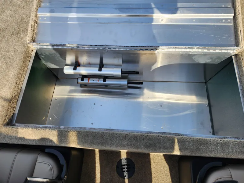 Slide: The Image of 2025 Tracker Bass Tracker Classic XL Limited storage compartment with metal interior and fishing rod holders. - 14