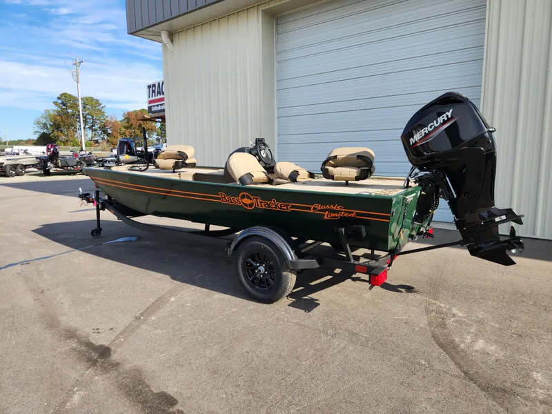 Slide: The Image of 2025 Tracker Bass Tracker Classic XL Limited boat with Mercury engine parked outside. - 2