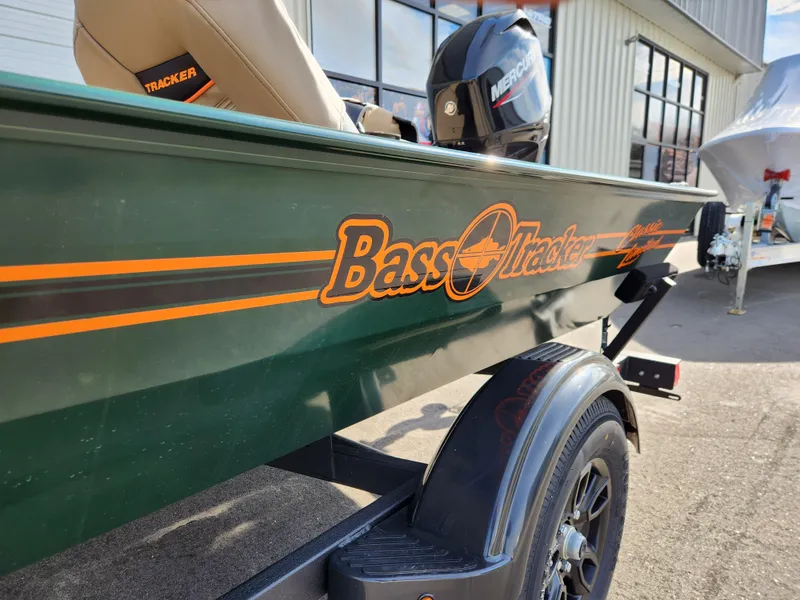 Slide: The Image of 2025 Tracker Bass Tracker Classic XL Limited boat with Mercury engine, parked outdoors. - 26