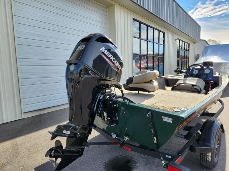 Slide: The Image of 2025 Tracker Bass Tracker Classic XL Limited boat with Mercury engine, parked outside. - 6