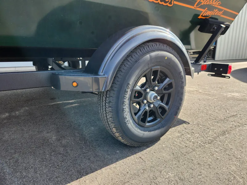 Slide: The Image of 2025 Tracker Bass Tracker Classic XL Limited trailer wheel on asphalt. - 7