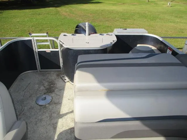 Slide: The Image of 2020 Bennington SFX22 pontoon boat interior with seating and motor, on grassy background. - 3