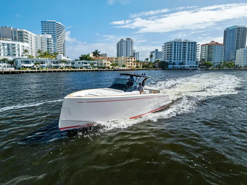 Slide: The Image of Pardo Yachts 38 cruising on water, city skyline in background, 2021 model. - 20