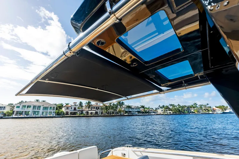 Slide: The Image of Pardo Yachts 38 (2021) with sunroof, overlooking waterfront homes and blue sky. - 36
