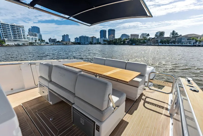 Slide: The Image of Pardo Yachts 38, 2021 model, luxury deck with seating and table, city skyline view. - 38