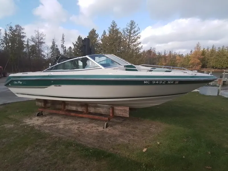 The Image of 1988 Sea Ray 20 Seville boat on display outdoors, surrounded by trees. - 0