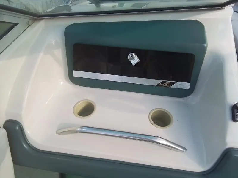 Slide: The Image of 1988 Sea Ray 20 Seville dashboard with storage compartment and cup holders. - 18