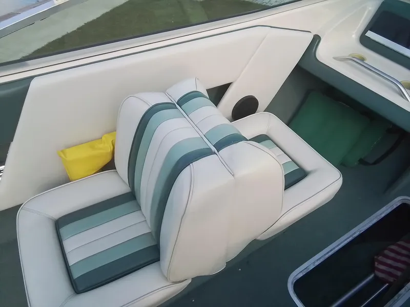 Slide: The Image of 1988 Sea Ray 20 Seville boat interior with striped seats and storage compartments. - 20