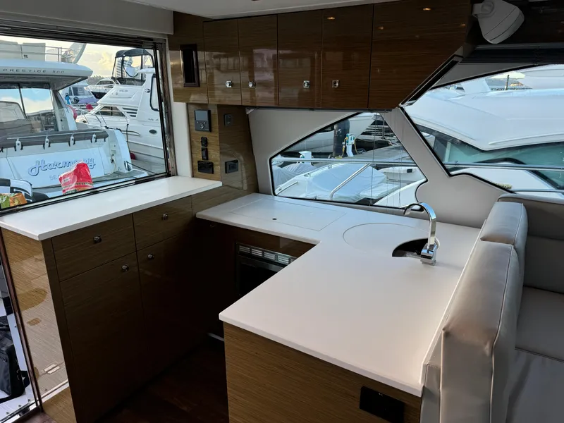 Slide: The Image of Interior of 2018 Cruisers Yachts 50 Cantius with modern kitchen and marina view. - 12