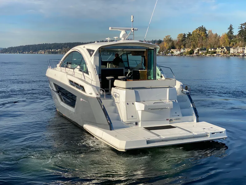 Slide: The Image of 2018 Cruisers Yachts 50 Cantius on serene water, showcasing sleek design and luxury features. - 2