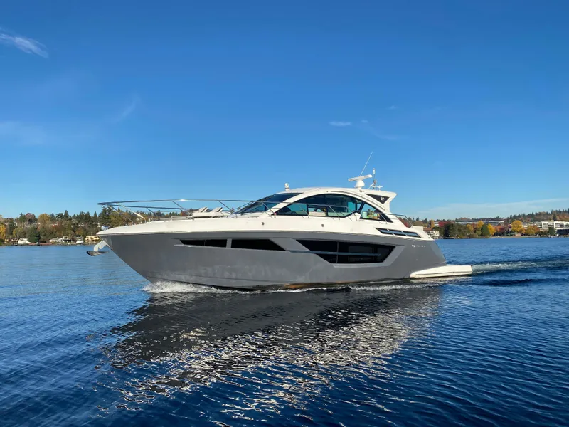 Slide: The Image of 2018 Cruisers Yachts 50 Cantius cruising on a serene lake under a clear blue sky. - 4