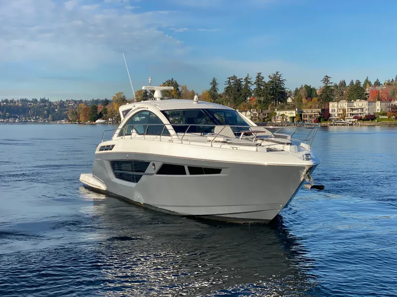 The Image of 2018 Cruisers Yachts 50 Cantius on serene lake with scenic background. - 0