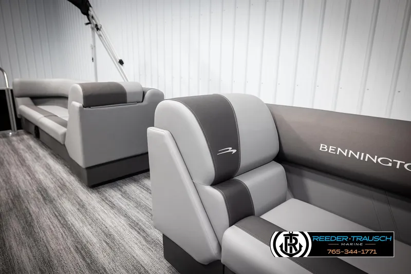 Slide: The Image of 2025 Bennington 23 SSRSE boat interior with gray seating and logo, displayed indoors. - 21
