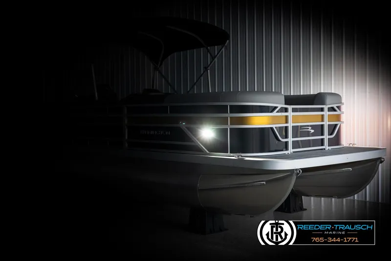 Slide: The Image of 2025 Bennington 23 SSRSE pontoon boat in dimly lit showroom, highlighting sleek design. - 4