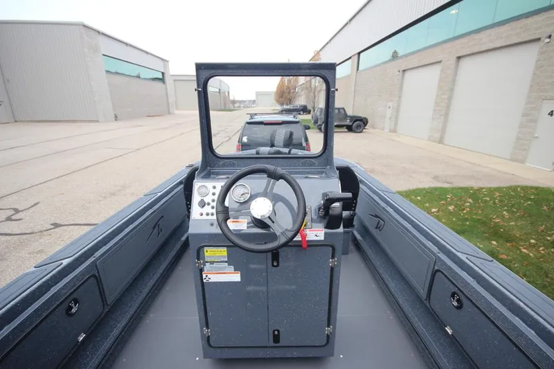 Slide: The Image of 2025 Weldcraft 200 Rebel Open boat interior with steering console, parked outdoors. - 18