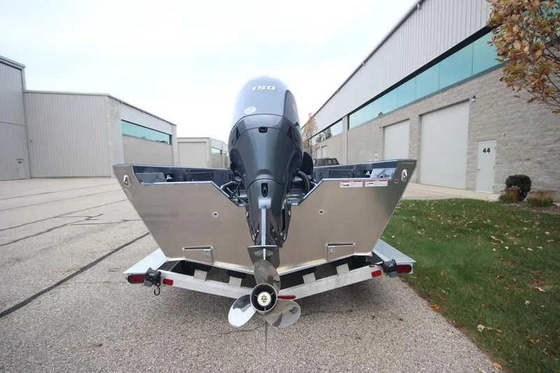 Slide: The Image of 2025 Weldcraft 200 Rebel Open with F150hp engine, parked outside industrial building. - 7