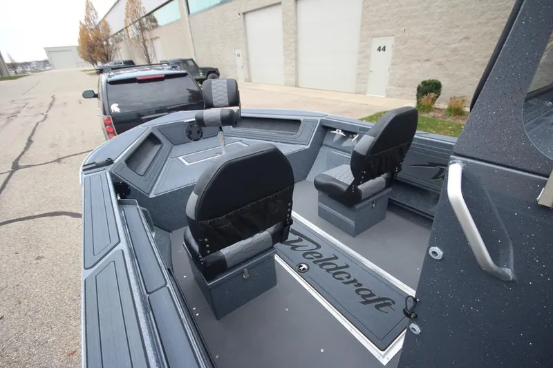 Slide: The Image of 2025 Weldcraft 200 Rebel Open boat interior with two seats, parked on a street. - 9