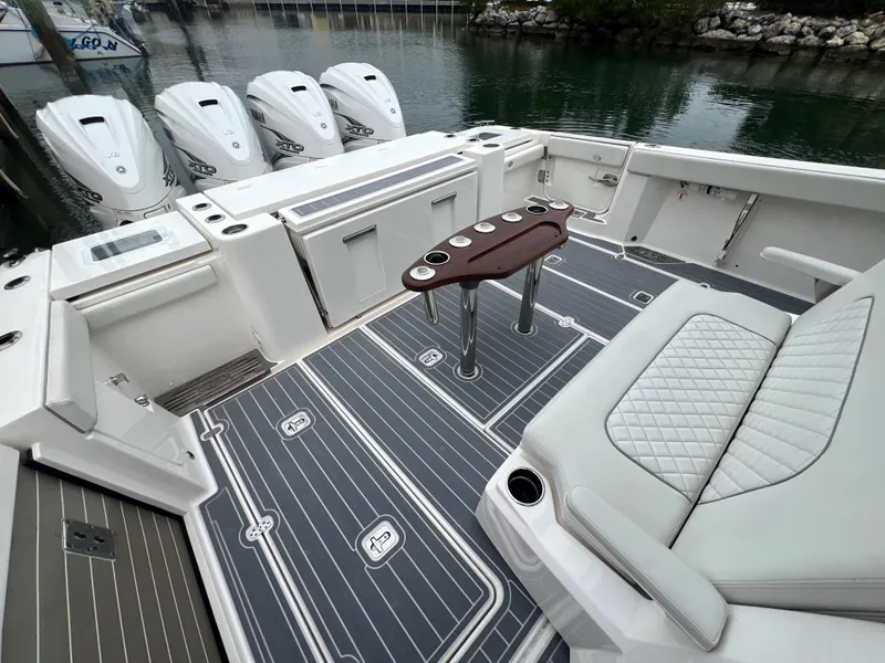 Slide: The Image of 2023 Pursuit 428 Sport boat deck with seating and multiple outboard engines. - 11