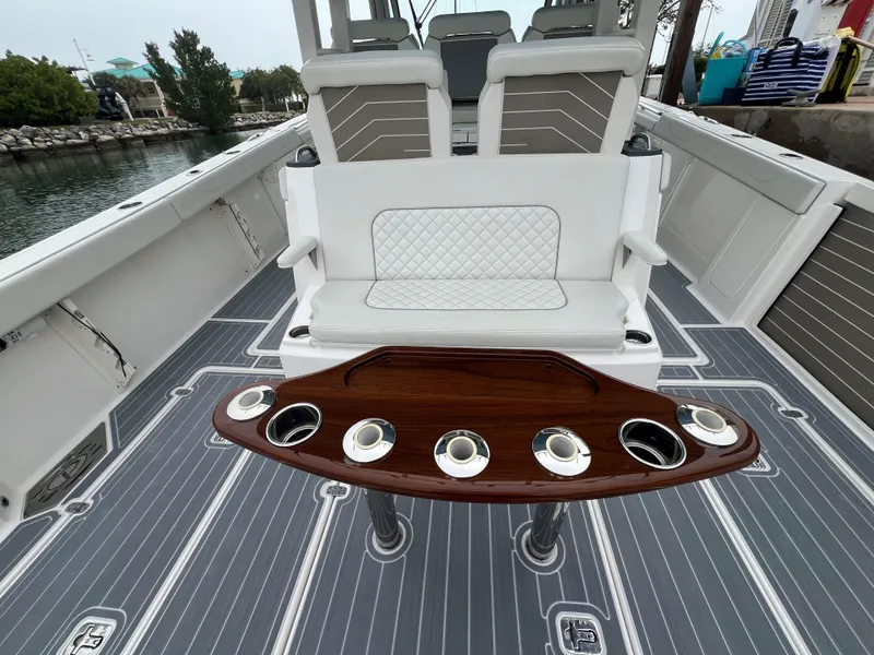Slide: The Image of 2023 Pursuit 428 Sport boat interior with seating and cup holders. - 12