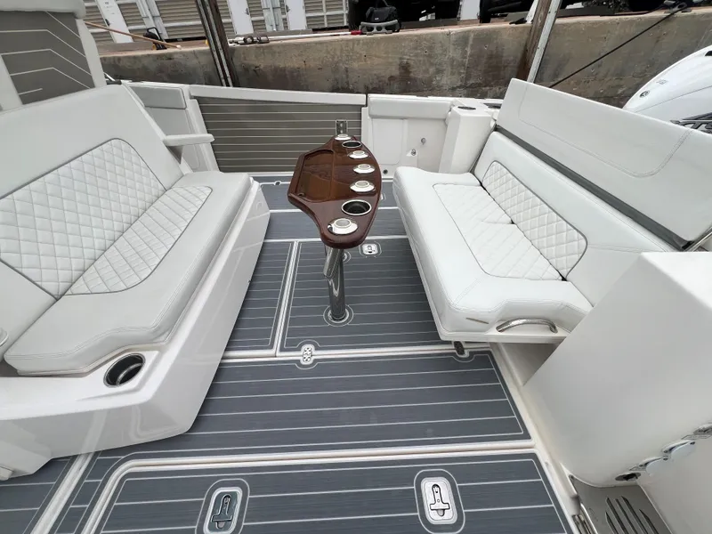Slide: The Image of 2023 Pursuit 428 Sport boat interior with cushioned seating and table. - 25