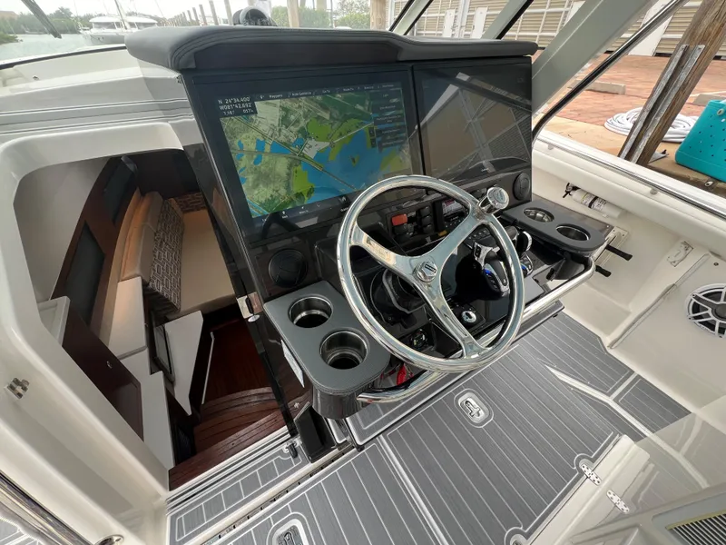 Slide: The Image of 2023 Pursuit 428 Sport boat helm with navigation screens and steering wheel. - 28