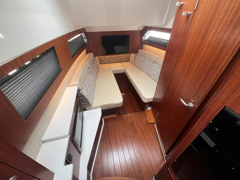Slide: The Image of Luxurious interior of 2023 Pursuit 428 Sport boat with wood finishes and cozy seating. - 29