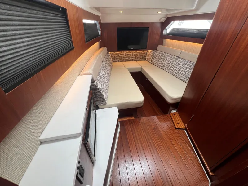 Slide: The Image of Luxurious interior of 2023 Pursuit 428 Sport boat with wood flooring and plush seating. - 30