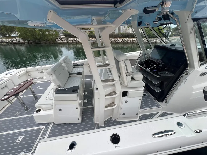 Slide: The Image of 2023 Pursuit 428 Sport boat interior with seating, helm, and ladder. - 8